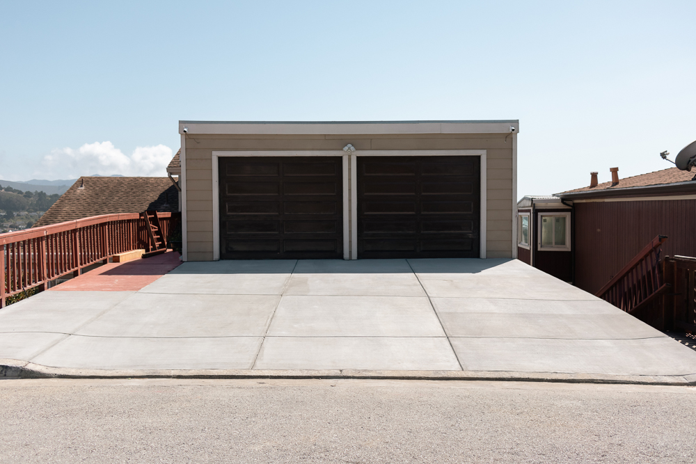 concrete driveway with two garage doors